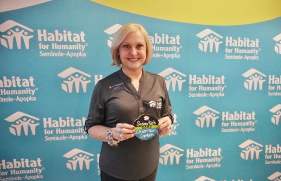 Susan Rich holding up a Habitat for Humanity award